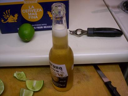 Corona beer bottle with limes and bottle opener on counter