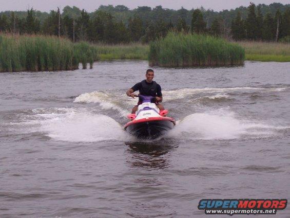 Jet ski with rider on water, creating spray