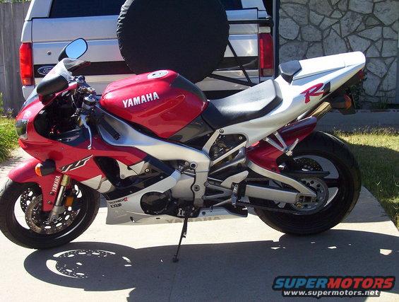 Red and white Yamaha R1 motorcycle parked in front of a Ford Bronco