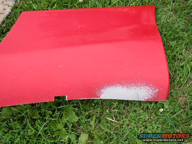 red car door with primer showing on lower right