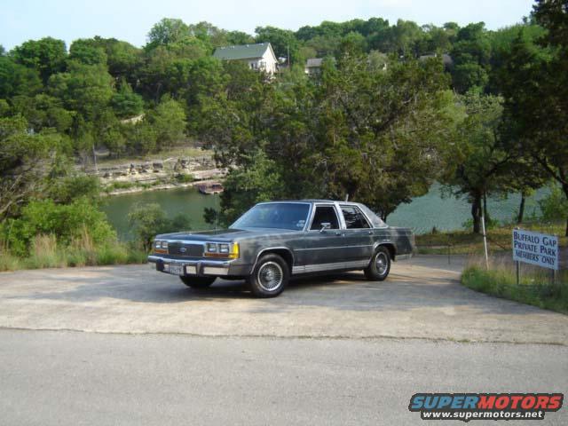 Gray sedan parked by a lake with trees and a sign that says 'Buffalo Gap Private Park Members Only'