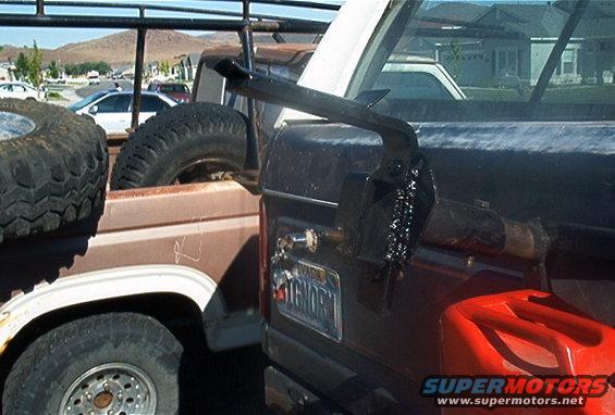 I cut a piece of 2x4" square tube and welded it to the stock tire carrier part.  I then drilled the square tube and welded a 1/2 ton lug from inside the tube.