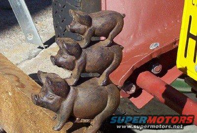 Stack of three cast iron pigs, a decorative automotive part