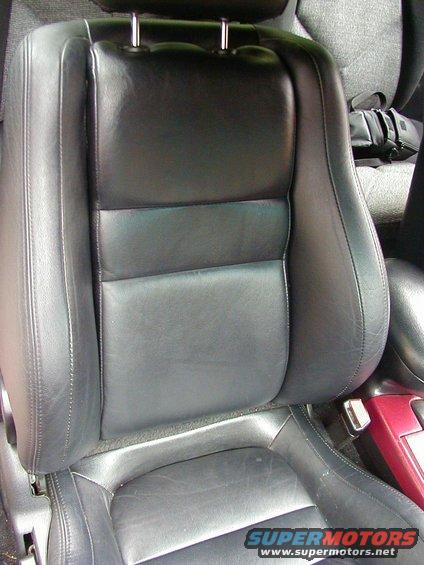 black leather car seat with red trim visible on the right