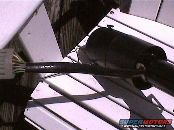 Steering column wiring harness with a white connector and black tape