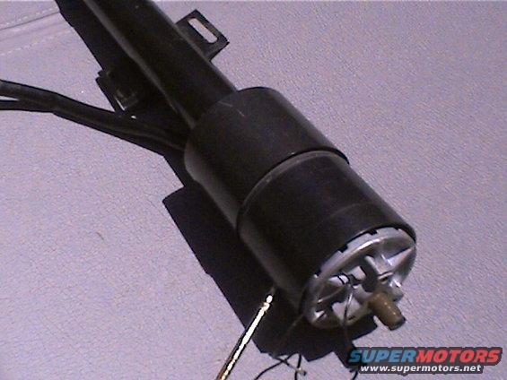 Black steering column part with metal components and wires against a textured gray surface