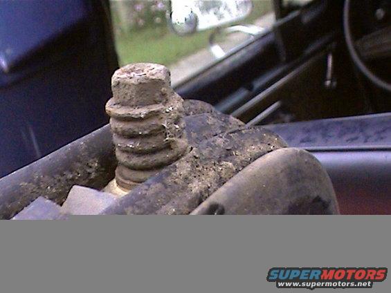 Close-up of a heavily rusted bolt with ribbed texture
