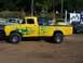 1994 Ford F-150 - This yellow 1956 Ford F-100 pickup truck features custom flame graphics and various sponsor text on its side.