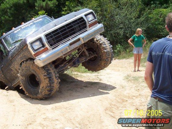 Mud-covered 1979 Ford truck with front wheel lifted high off the ground