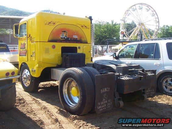 Yellow semi-truck cab with mural, rear view