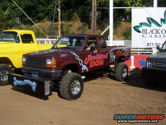 Maroon pickup truck with "Junkydog" graphics, lifted suspension, and custom bumper