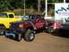 1994 Ford F-150 - A heavily modified pickup truck with custom paint and lifted suspension is parked next to other vehicles.