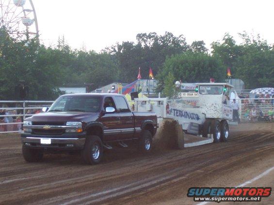 Maroon pickup truck, 1999 Chevrolet Silverado, pulling a trailer labeled "TERMINATOR" in a dirt track event