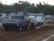 1994 Ford F-150 - A lifted 1975 Ford F-150 truck competes in a pull event, dragging a sled on a dirt track.
