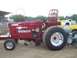 1994 Ford F-150 - A modified red tractor with "POWER TRIP" branding is parked next to a yellow and white pickup truck.