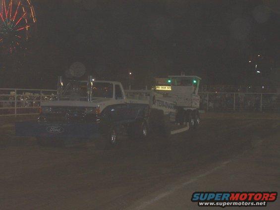 1994 Ford F-150 towing a trailer with 'TERMINATOR' on the side, fireworks in the background
