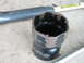 1995 Ford Bronco - A damaged socket wrench part shows significant wear and rust around its edges.