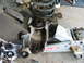 1995 Ford Bronco - A rusty suspension part is shown on a floor jack, with other disassembled components nearby.
