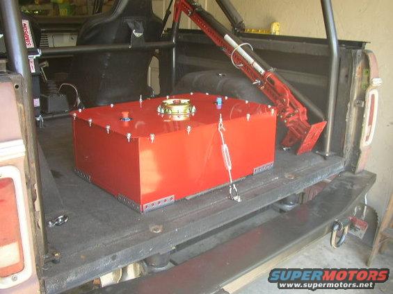 Red auxiliary fuel tank and roll cage inside a vehicle's cargo area