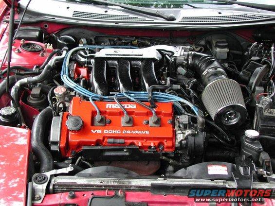 Engine bay with red Mazda V6 DOHC 24-valve engine cover and aftermarket air filter