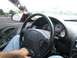 1994 Ford Probe - Interior view of a car, focusing on the steering wheel and dashboard gauges, with a glimpse of the exterior through the side window.