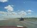 1994 Ford Probe - A 1994 Ford Probe travels down a highway under a partly cloudy sky, with another vehicle visible on the right.