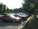 1994 Ford Probe - Several cars are parked in a lot outside a building on a sunny day.