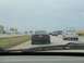 1994 Ford Probe - A black sedan is seen from behind while driving on a highway with other vehicles.