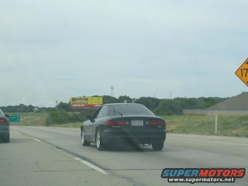 Black 1994 Ford Probe rear view on highway