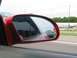 1994 Ford Probe - A red car's side mirror shows a black car in its reflection.