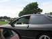 1994 Ford Probe - Side view of a black 1994 Ford Probe with a driver behind the wheel, seen from another vehicle.