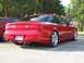1994 Ford Probe - A red sports coupe is parked in a lot, with another vehicle and several people visible.