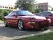 1994 Ford Probe - A red 1994 Ford Probe is parked in a lot, showing its front 3/4 view with pop-up headlights visible.