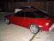 1994 Ford Probe - A red coupe is parked in a driveway next to a white car, with its rear bumper removed.