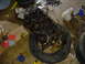 1986 Ford Mustang - An engine block sits on a tire in a garage, surrounded by tools and debris, suggesting a repair or rebuild in progress.