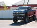 1991 Ford Bronco - This heavily modified pickup truck features a prominent lift kit and custom graphics on its side panels.