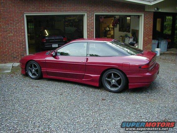 Red 1994 Ford Probe parked in a driveway, another car visible in the garage