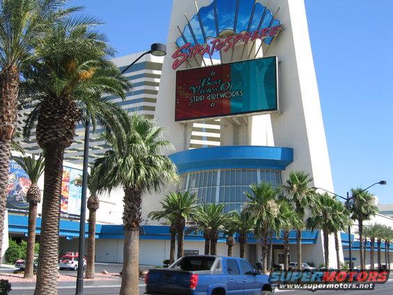 Blue pickup truck from the rear, parked on a street in front of the Stratosphere hotel