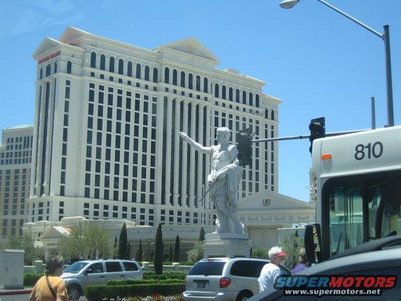 Caesars Palace hotel in Las Vegas, a statue of a Roman figure, and several vehicles including a bus numbered 810