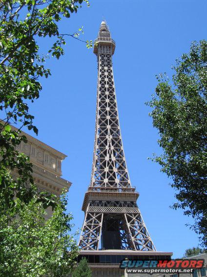 Eiffel Tower replica with trees and a building in front