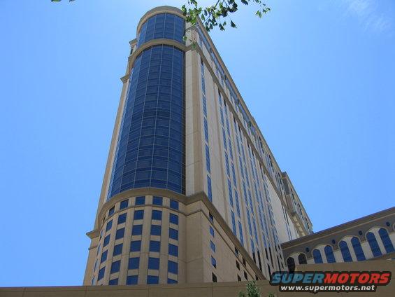 Tall building with curved glass facade and arched windows under a clear blue sky