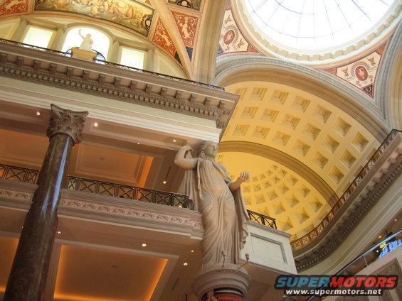 Interior architecture with statues and a dome ceiling, SuperMotors logo visible