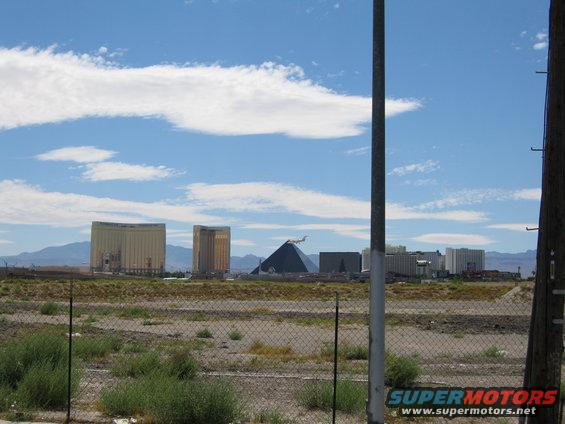 Las Vegas skyline with Luxor Pyramid and hotels, seen through a chain-link fence
