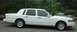 1997 Ford Crown Victoria - This white Lincoln Town Car is shown from the side. The vehicle has tinted windows and a distinctive body style.