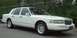 1997 Ford Crown Victoria - This white sedan has a distinctive grille and body style, suggesting a mid-1990s model year.