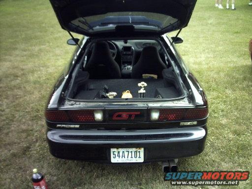 Rear view of a black Mazda MX-6 GT with trunk open, showing trophies inside. License plate reads 54A7101