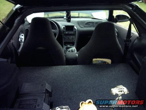Interior view of a 1995 Ford Probe showing front seats, dashboard, and cargo area with trophies