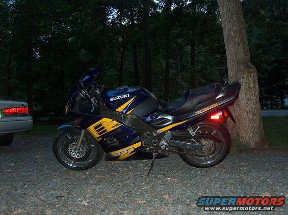 2002 Suzuki TL1000R motorcycle, blue and yellow, parked on gravel near a tree