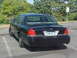 1999 Ford Crown Victoria - Black Ford Crown Victoria sedan parked in a lot with trees in the background.