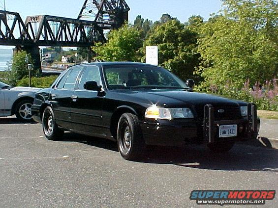 Black Ford Crown Victoria police car, front 3/4 view, with push bumper and license plate 1431